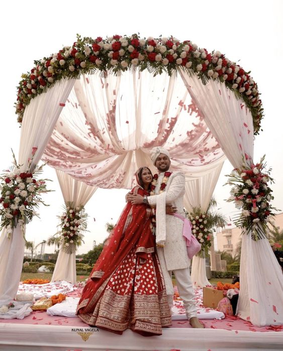 Bride and groom under a floral mandap celebrating their wedding day with Swariya Weddings